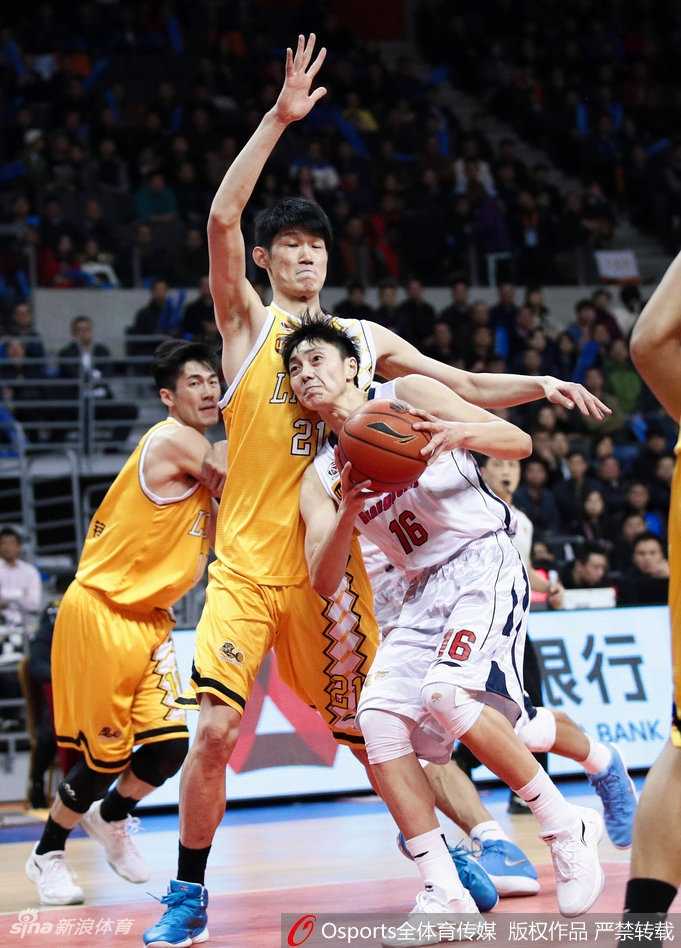 广东核心易建联在对方内线多人包夹下高高跃起，强硬摘下一个宝贵的前场篮板，落地瞬间他肌肉紧绷，展现了中国男篮领军人物的力量与决心。