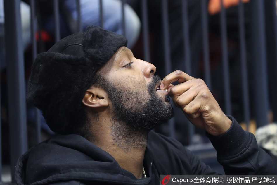 布莱切坐在替补席上开怀大笑，露出洁白的牙齿，似乎被队友的精彩表现完全逗乐了。