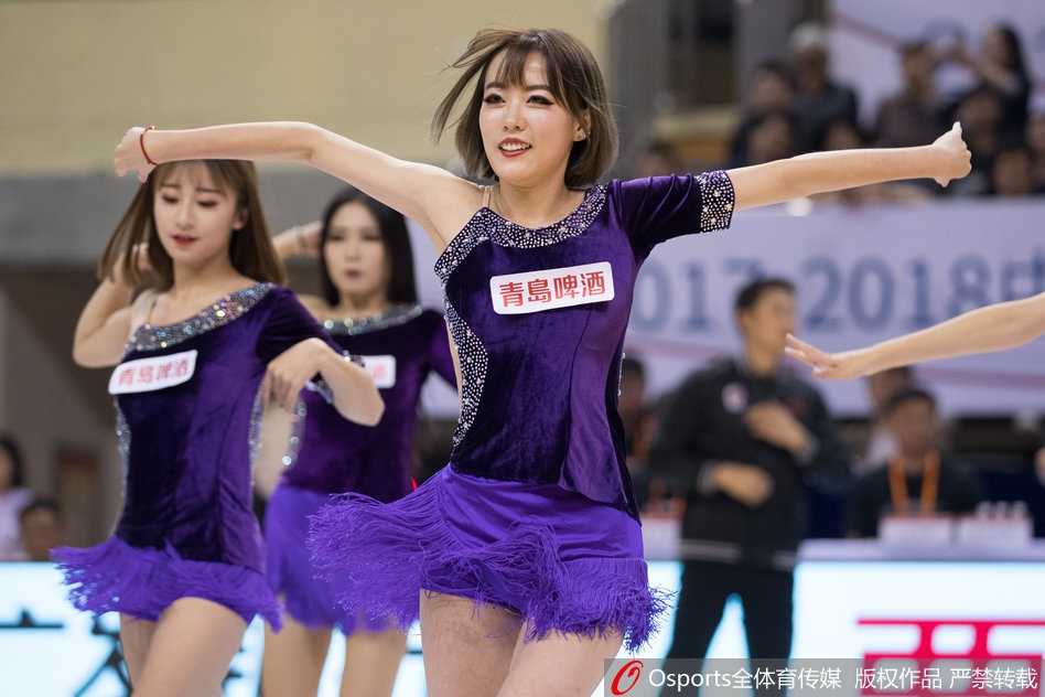 聚光灯外的舞者:江苏肯帝亚篮球宝贝的汗水与梦想 几位篮球宝贝蹲在地上围成一圈,似乎正在进行上场前最后的战术讨论与互相加油鼓劲。她们的妆容精致,眼神中充满了对即将开始的表演的期待与坚定。