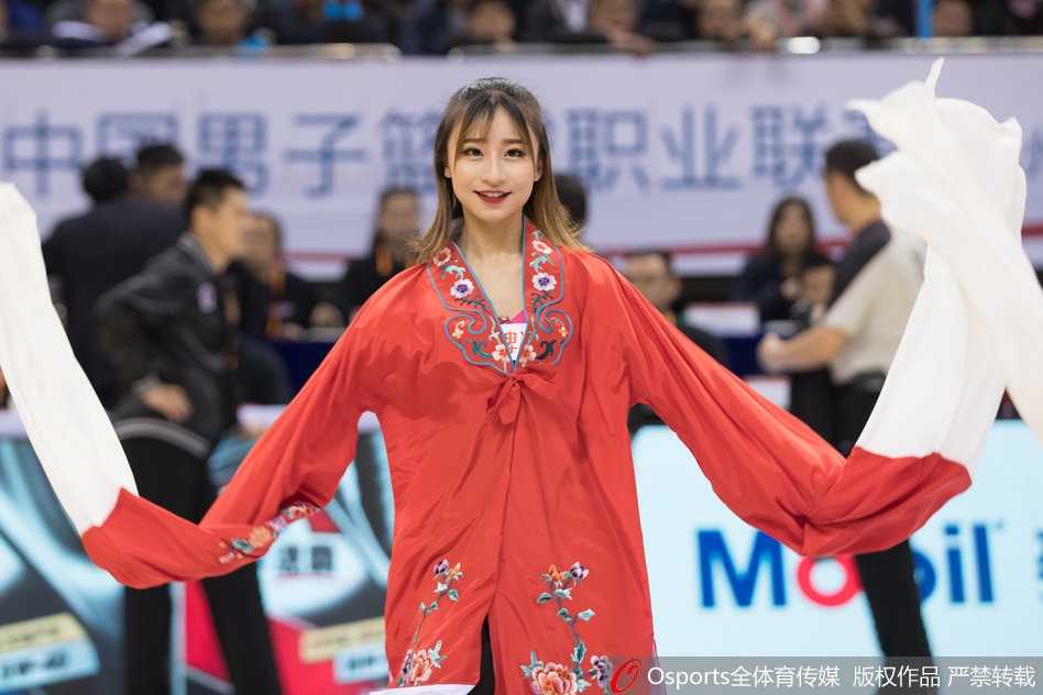 肯帝亚篮球宝贝甩袖舞惊艳赛场 一位篮球宝贝面带自信微笑,侧身扬袖,长袖在空中舒展开来,露出袖里精致的梅花刺绣