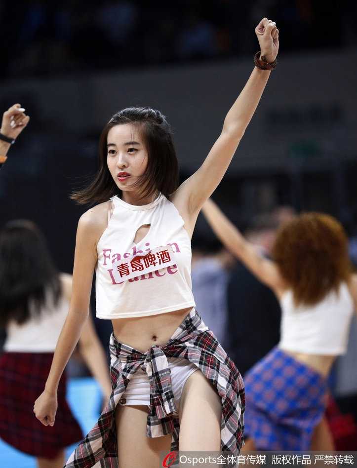 台北富邦勇士啦啦队成员柠檬在球场上热舞，新版粉蓝相间的低胸队服因动作过大而肩带滑落，她一边敬业地保持微笑律动，一边用手轻轻拉回滑落的细带