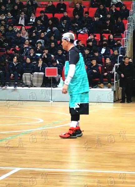 本山大叔在罚球线附近从容跳投，手势标准，篮球在空中划出一道优美的弧线，场边观众目光齐聚