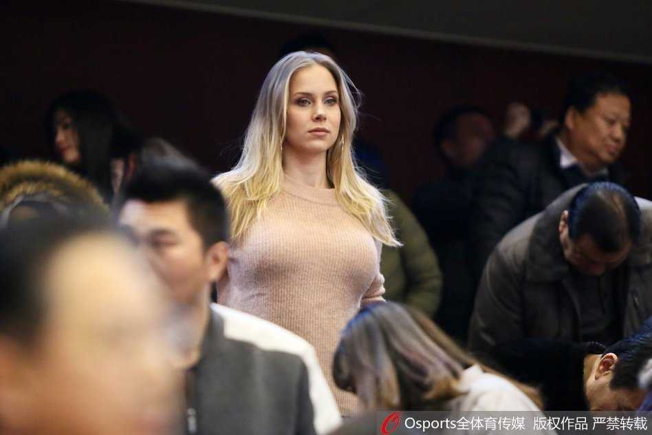 莫泰尤纳斯的妻子与身边的亲友团成员交流，脸上洋溢着轻松的笑容，显然对丈夫在场上游刃有余的表现感到十分安心和骄傲。