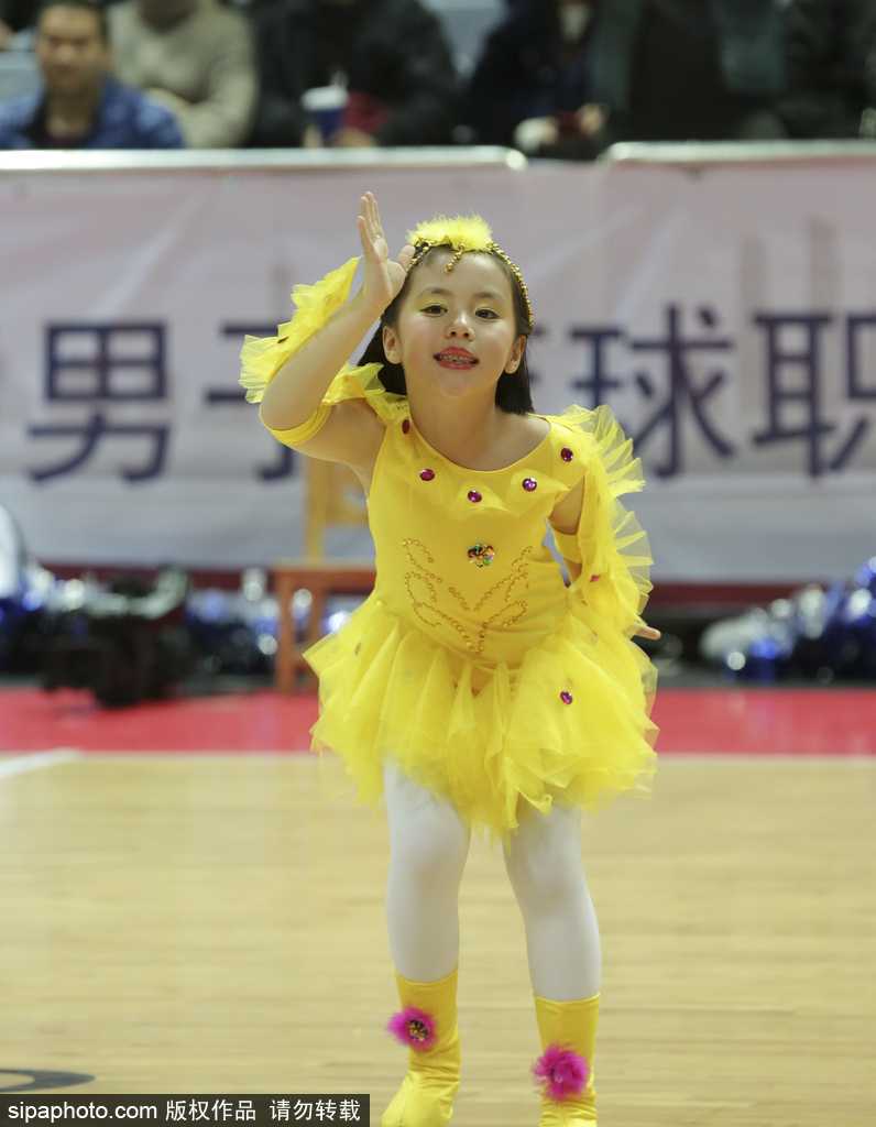 萌娃空降甬城赛场 CBA迎来最萌啦啦队 侧拍镜头下,一名萌娃啦啦队员高高举起手中的彩球,仰头看向空中的花球,眼神中充满好奇与星光,上扬的嘴角透露出表演带来的纯粹快乐。