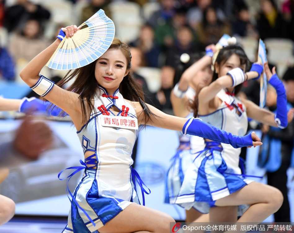 特写镜头下，一位啦啦队女孩笑容甜美，头上戴着一对毛茸茸的狐耳发饰，与身上帅气的战衣形成强烈的“反差萌”，她手中挥舞着金色的花球，仿佛是从二次元世界穿越到篮球场的元气少女。