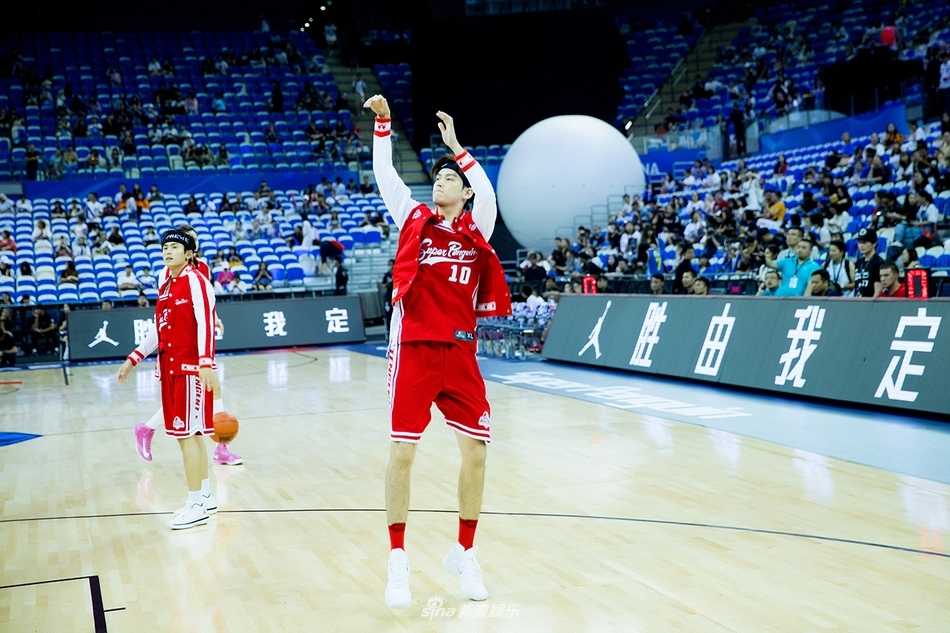 董力在场上双手抱球做出投篮预备姿势，背景是座无虚席的东方体育中心看台，灯光璀璨气氛热烈