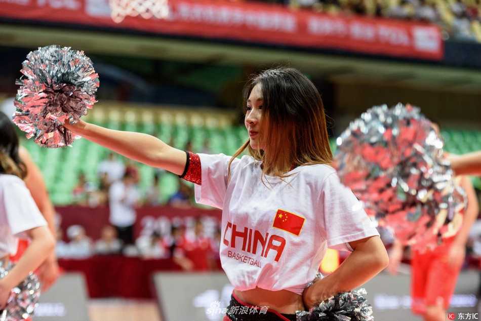 蓉城夏夜篮球火 红队激战安哥拉 宝贝热舞燃爆全场 镜头聚焦于一位笑容甜美的啦啦队员,她手持闪亮的花球,眼神充满自信,身后的队友虚化成光影,仿佛整个舞台都为她闪耀。