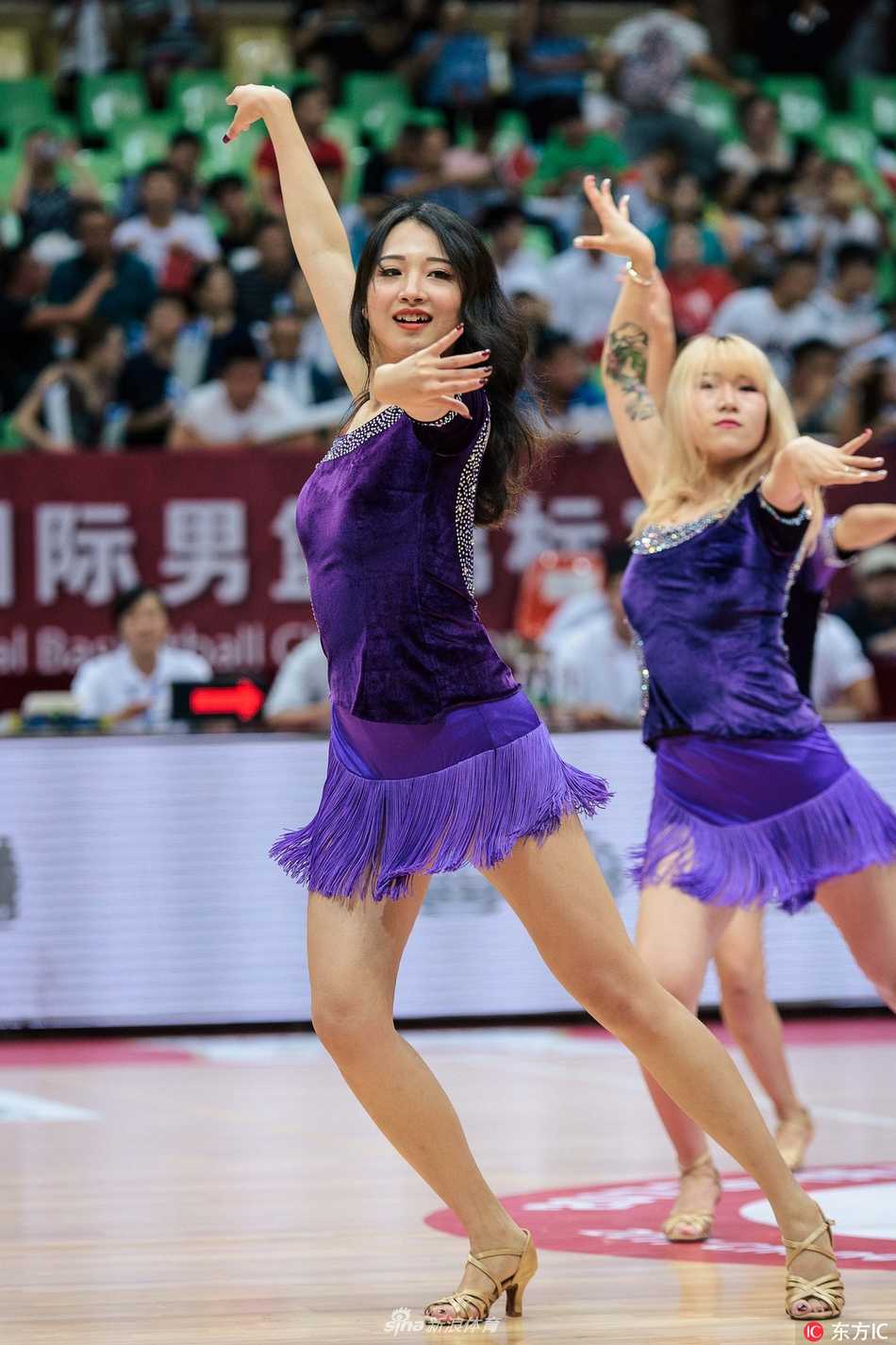 蓉城激战之下的热辣风景线 男篮红队大胜新西兰 镜头定格在一位篮球宝贝的回眸瞬间,她身姿挺拔,流苏随动作摇曳,动感身影与场馆内绚烂灯光交织,宛如赛前最迷人的序曲。