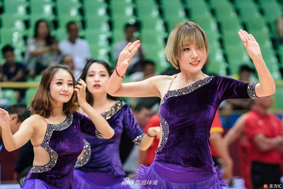 蓉城激战之下的热辣风景线 男篮红队大胜新西兰 一名篮球宝贝在聚光灯下展现柔美身姿,她轻轻扭动腰肢,双手优雅伸展,仿佛一朵在赛场边盛放的铿锵玫瑰,与身后激烈的计分牌形成一动一静的巧妙对比。