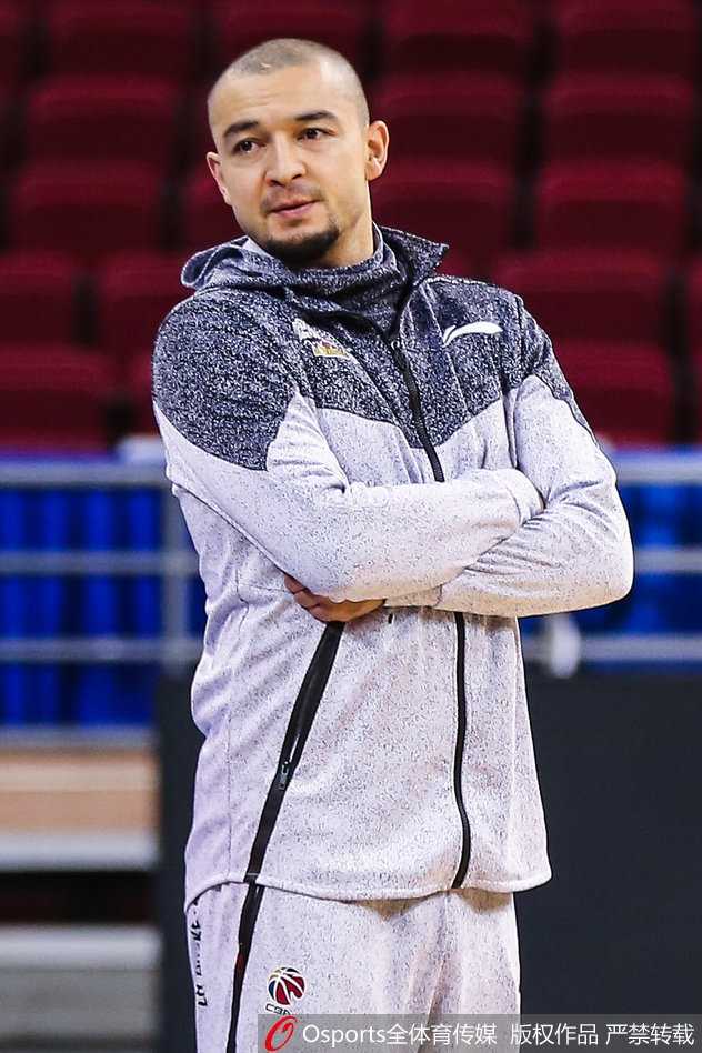 西热力江低头专注地系着鞋带，额头上的汗水诉说着训练的刻苦，红色的训练服映衬出他内心的火热与坚定