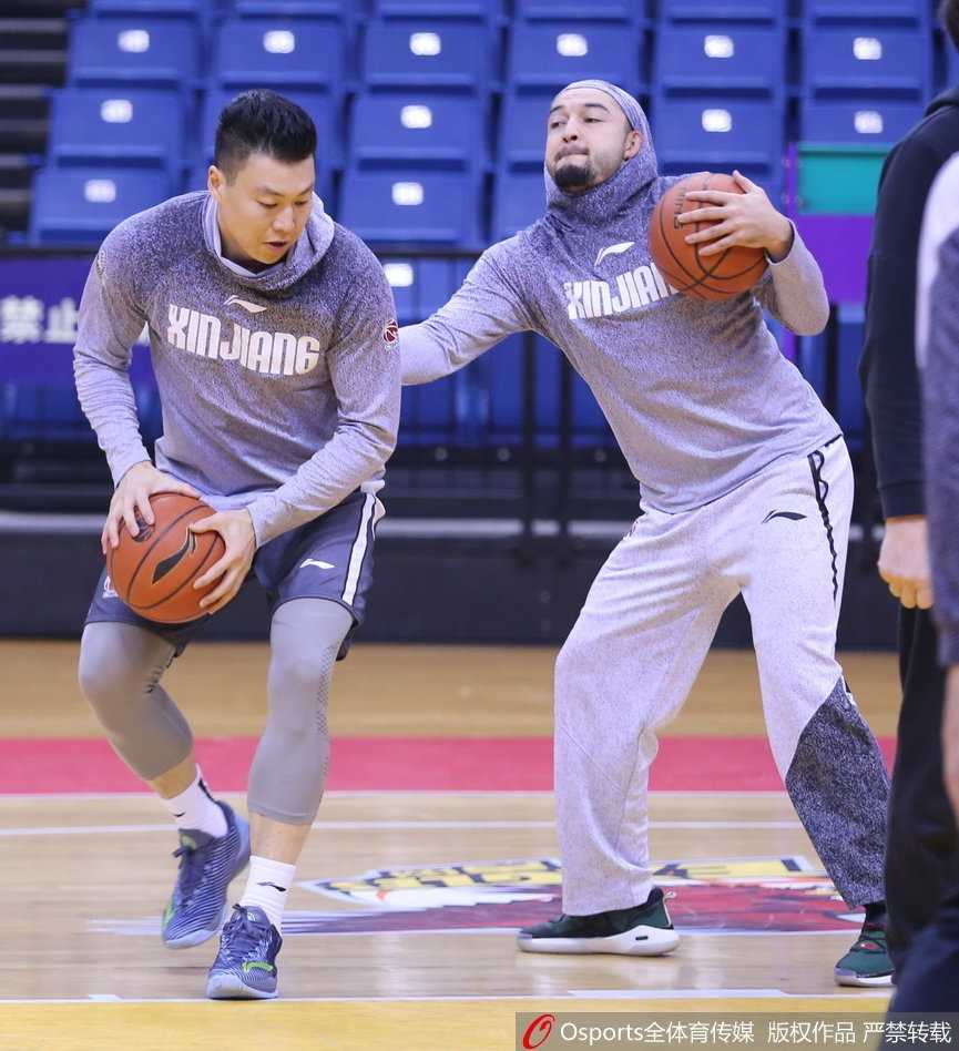 西热力江与李根在训练中一对一，两人脸上都带着笑意，但手上的动作却一丝不苟。