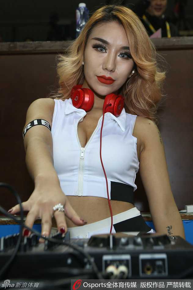 赛场上的别样风景 江苏肯帝亚美女DJ金发红唇抢镜 美女DJ在赛场边全神贯注地调试着混音台,精致的金发侧颜在灯光下格外迷人。