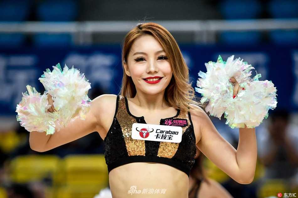 聚光灯下，一名篮球宝贝回眸一笑，甜美的面容与动感编发诠释赛场柔美瞬间