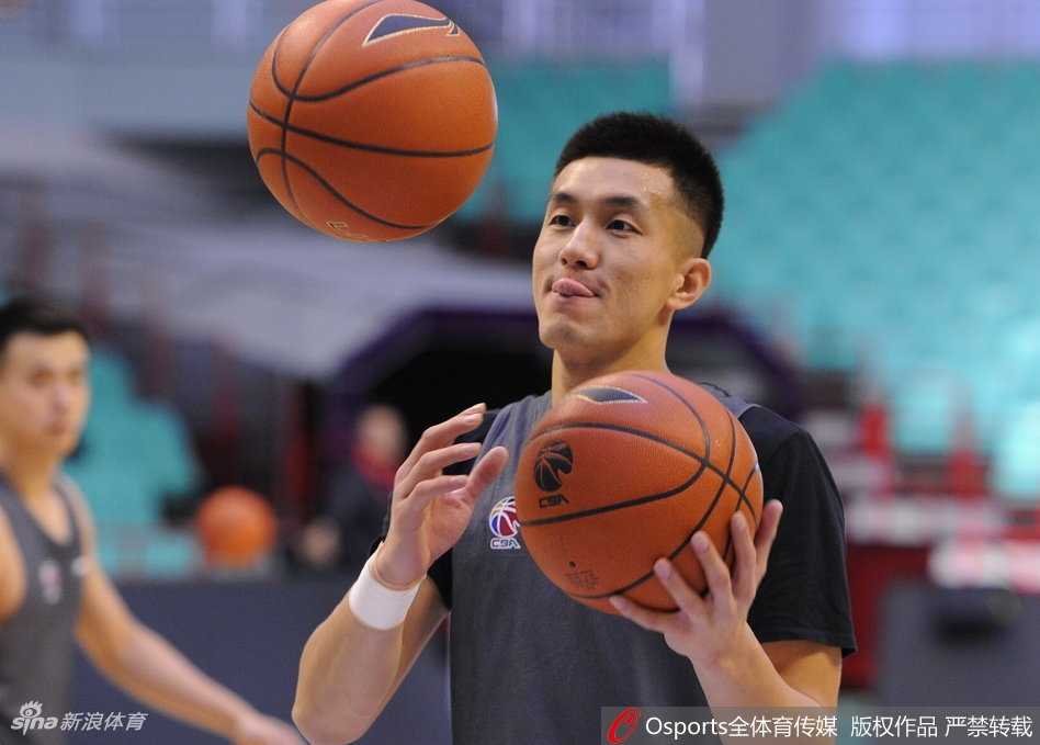 郭艾伦在热身队伍中做出夸张的防守姿势，表情专注中带着一丝笑意，仿佛在提前演练赛场上的斗志。