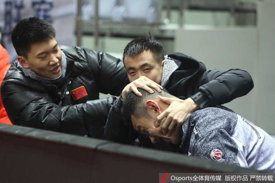 赵继伟走到场边，俯身听郭士强讲解战术，助教在旁边比划着手势，继伟频频点头，眼中透着思索