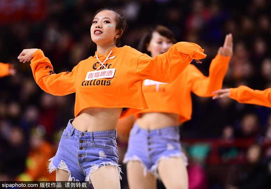 比赛进入暂停时段，宝贝们迅速集结成队形，高举双手随着音乐摆动。她们紧身的表演服上点缀着亮片，在灯光下闪闪发光，与球员湿透的球衣遥相呼应。