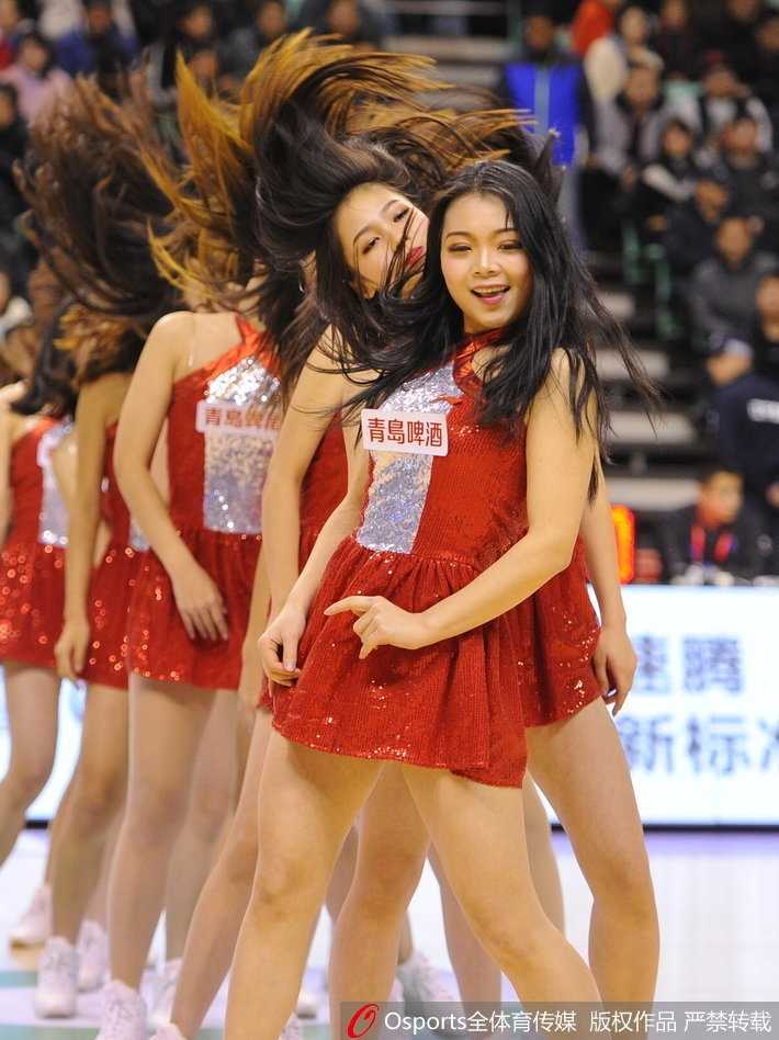 镜头拉近，这位宝贝的笑容格外甜美，手中的花球仿佛也被她的热情点燃。在寒冷的冬日，她们的存在就像一股暖流，让看台上的球迷忘却了严寒。