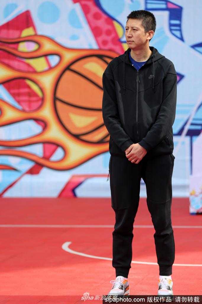 郭士强在活动现场将一件签有辽宁男篮全队将师名字的珍贵签名球衣赠送给主办方地产老总，两人握手致意。