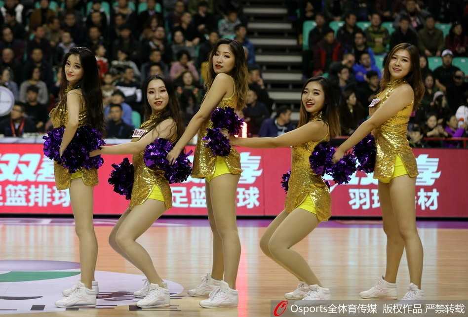 训练间隙，几位啦啦队队员在场边轻松互动，其中一位队员展现出极佳的柔韧性，一个漂亮的一字马赢得了同伴们的掌声和笑声。