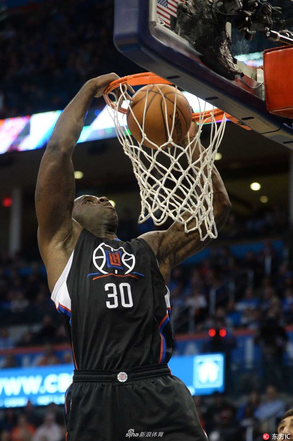 巴斯在NBA赛场上篮下强攻，肌肉线条分明，展现出强大的对抗能力和得分决心