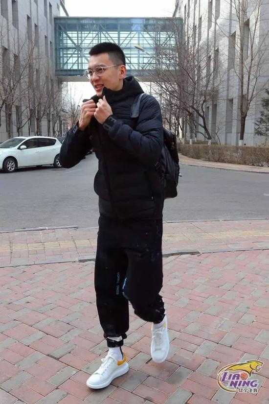 辽宁男篮的大巴车停在训练基地门口，车身上“辽宁本钢”的字样格外醒目，球员们正将行囊一一放入车厢，准备开启这段南下之旅。