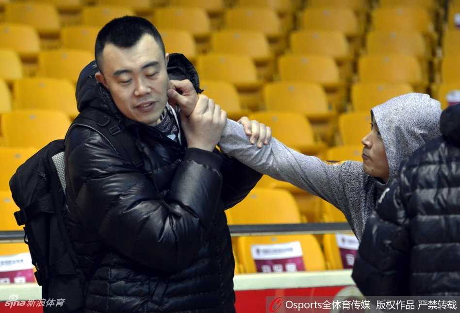 多名山东与辽宁的球员围在一起，气氛热烈，有人伸手试图拉扯队友，大家脸上都洋溢着笑容，将赛前的紧张感完全抛在脑后