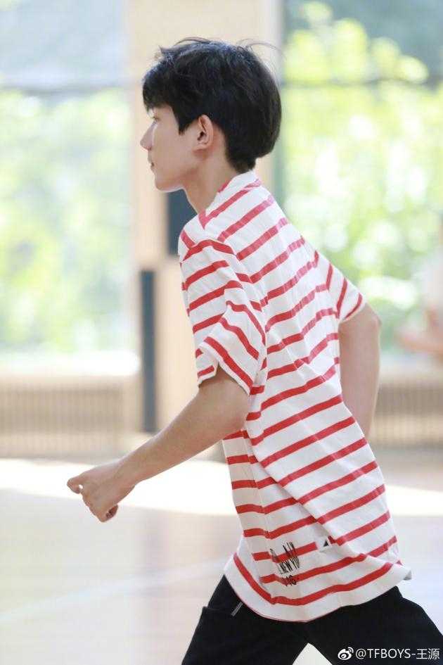 追风少年王源:篮球场上的红色闪电,定格十七岁的自由与热烈 王源在篮筐下回眸一笑,阳光透过条纹衫映出斑驳光影,黑色裤脚随动作轻扬,整个人像镀上一层青春的金边