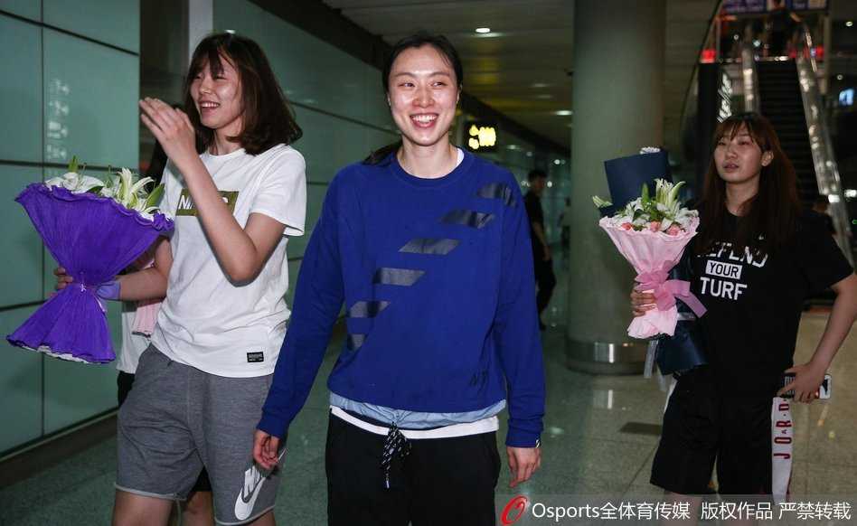 好友在机场大厅热情迎接邵婷，两人相拥而笑，场面温馨动人