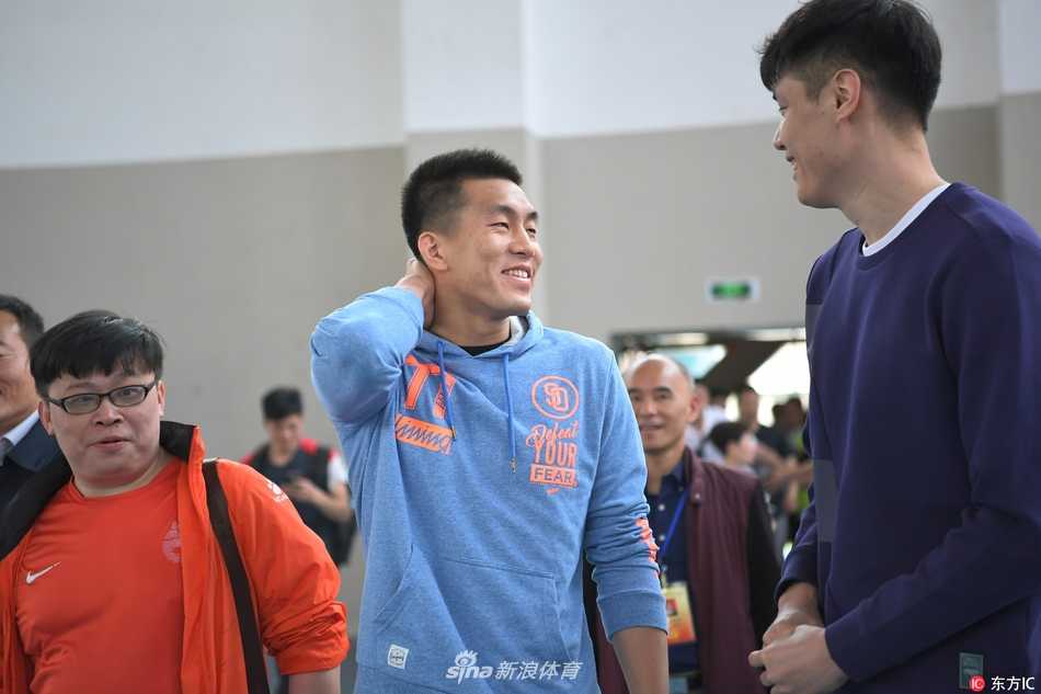 郭艾伦与贺天举刚刚踏进校园，便被热情的同学们团团围住，两人笑容满面地挥手致意，现场气氛热烈非凡。