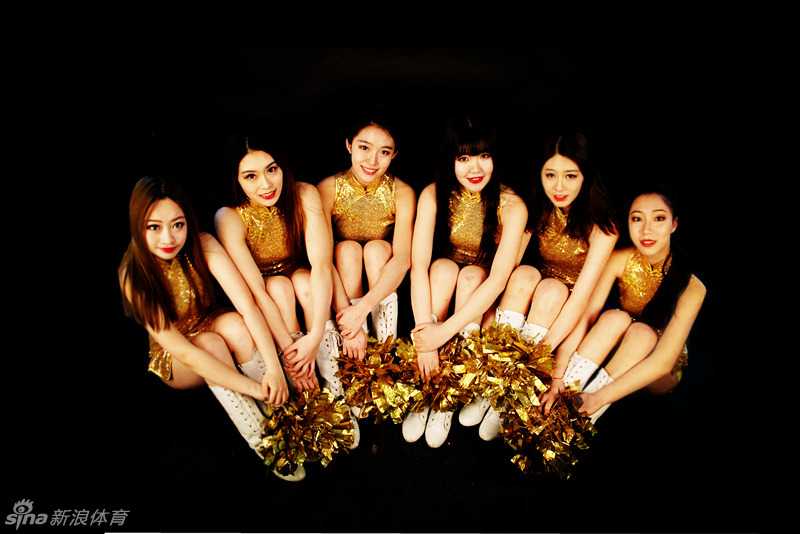 宝贝对着镜头开心地展示自己手中的中国结，身后是仿古的窗棂背景，整体画面充满了节日的喜庆与家庭的温馨感