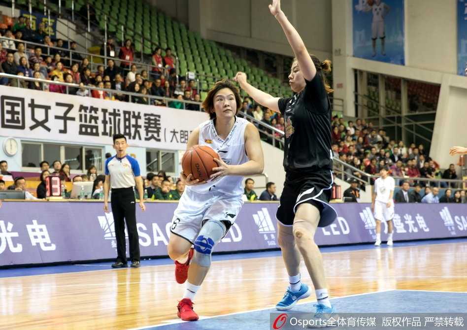 暂停期间，江苏队主教练手持战术板，半蹲在球员中间，用笔在板上飞快地画着战术，队员们围成一圈聚精会神地聆听，眼神中充满了对胜利的渴望和对教练的信任。