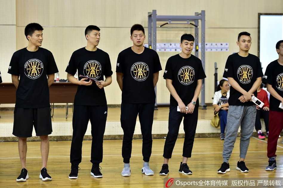 斯科拉为热情的球迷签名，他低着头专注地在篮球和球衣上留下自己的名字，浓密的胡须和专注的神情透露出他对球迷支持的珍惜与感激。