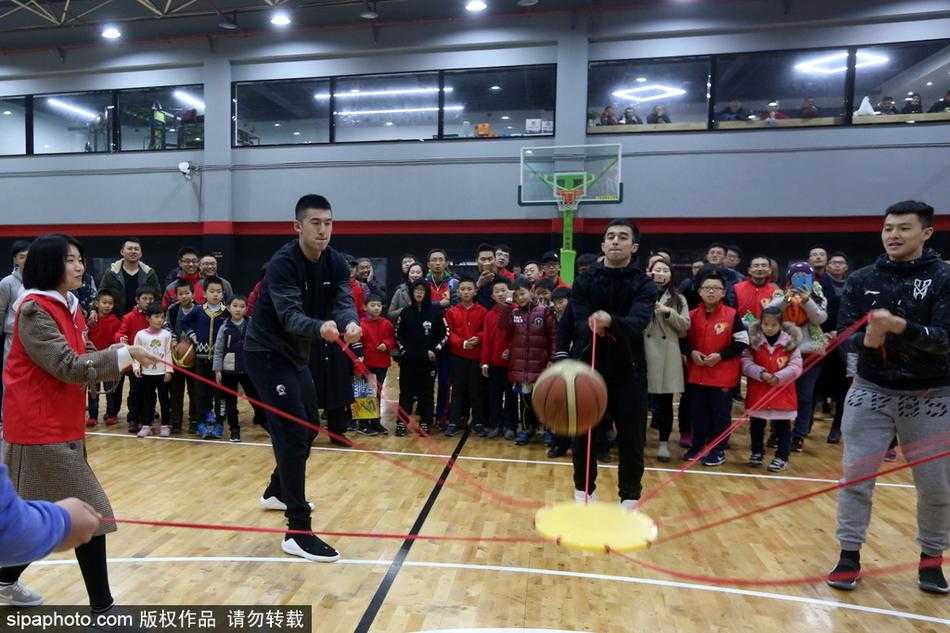 王中光指导被热情的球迷层层围住，他低头仔细辨认着球迷递来的每一件纪念品，眼神专注而亲切。