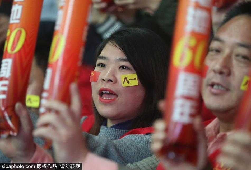 比赛进入白热化阶段，一位气质优雅的女球迷与同伴激动地讨论着场上局势，手中的加油棒高高举起，成为了看台上最亮眼的风景。