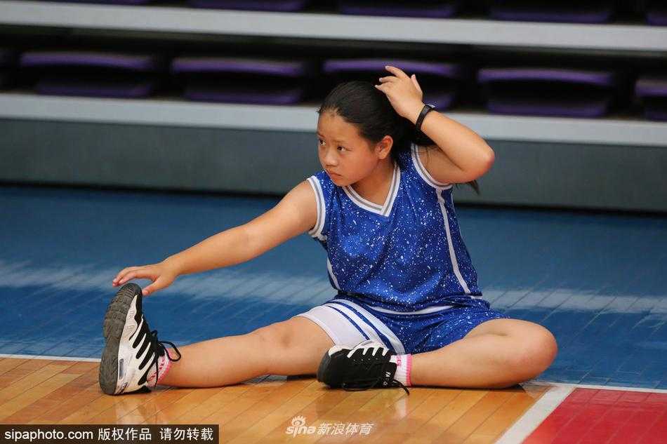 一场“厂BA”比赛暂停期间，企业职工啦啦队上场表演，笑容灿烂，背景是阜新著名的海州露天矿国家矿山公园。