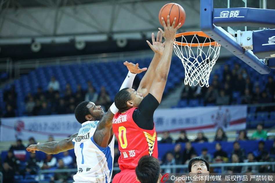 赛场上，双方球员在篮下激烈拼抢，肌肉碰撞瞬间迸发出力量感，展现了CBA联赛的激烈对抗程度。