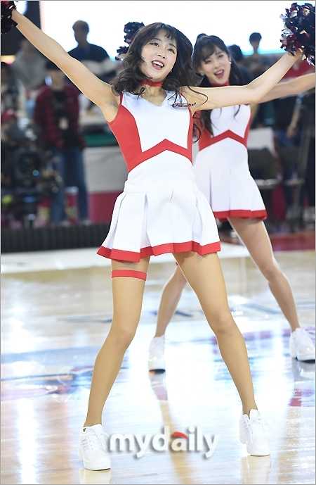 比赛高潮时刻，啦啦队员面对观众席绽放灿烂笑容，双手高举指向天空，调动全场球迷的欢呼情绪。