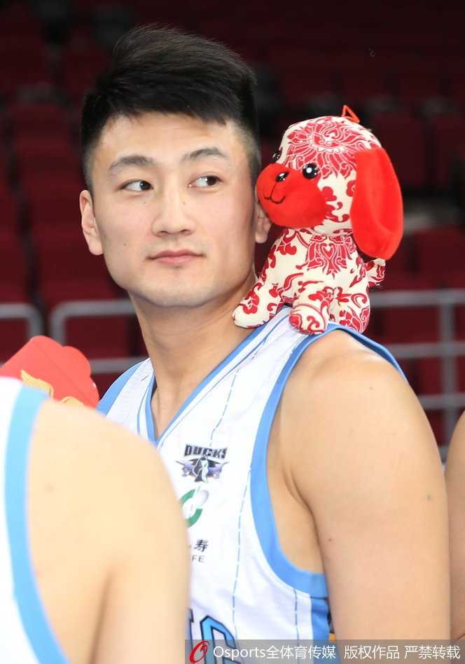 段江鹏独自怀抱一只金毛幼犬，眼神望向远方，仿佛在许下新年的篮球心愿