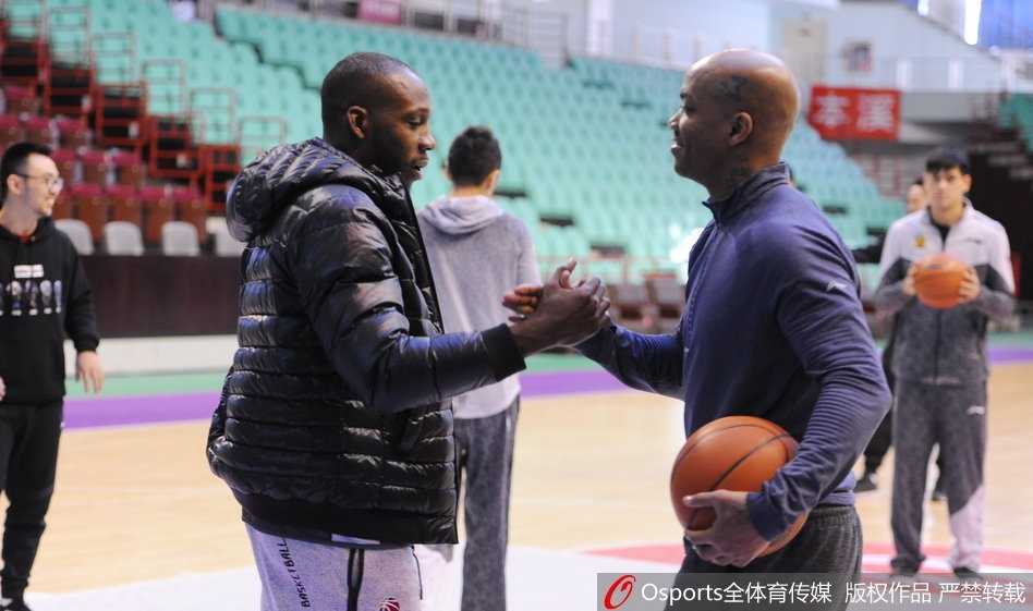 马布里与“哈小宝”的京城之约:那一抱,胜过千言万语 训练场上,哈德森露出标志性的憨厚笑容,马布里侧身与其交谈,两人身后的篮球架和队友构成背景,整个画面充满大战前夕难得的轻松与默契。