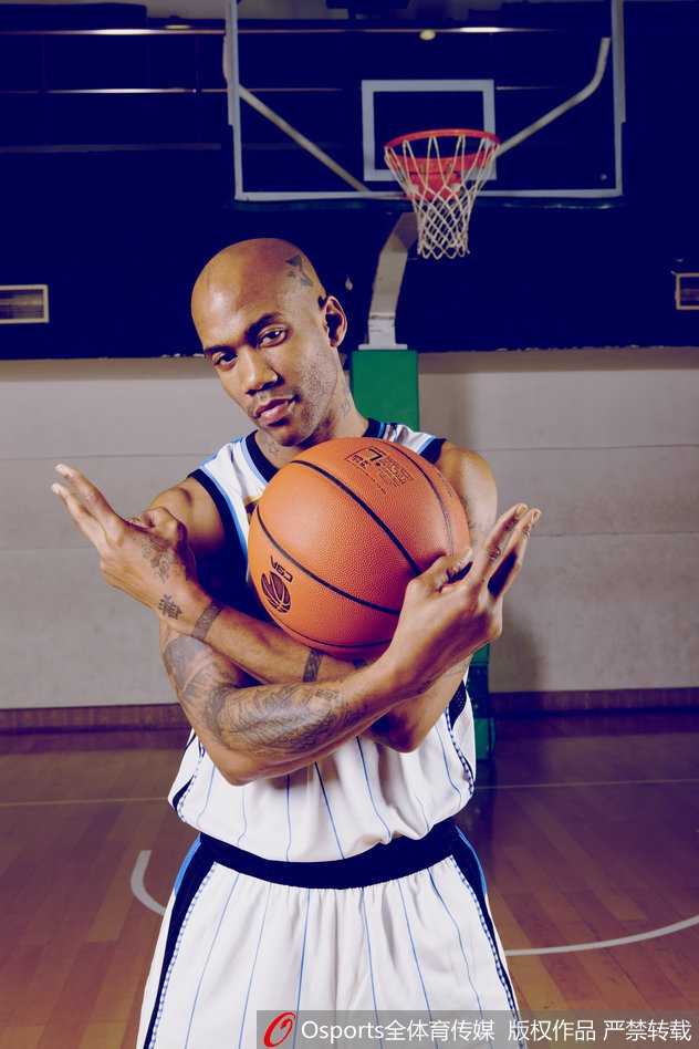 老马身穿深色西装，单手插兜，目光深邃地望向远方，背景是北京标志性的胡同，中西合璧的造型恰如他在中国的生活，时尚又接地气。