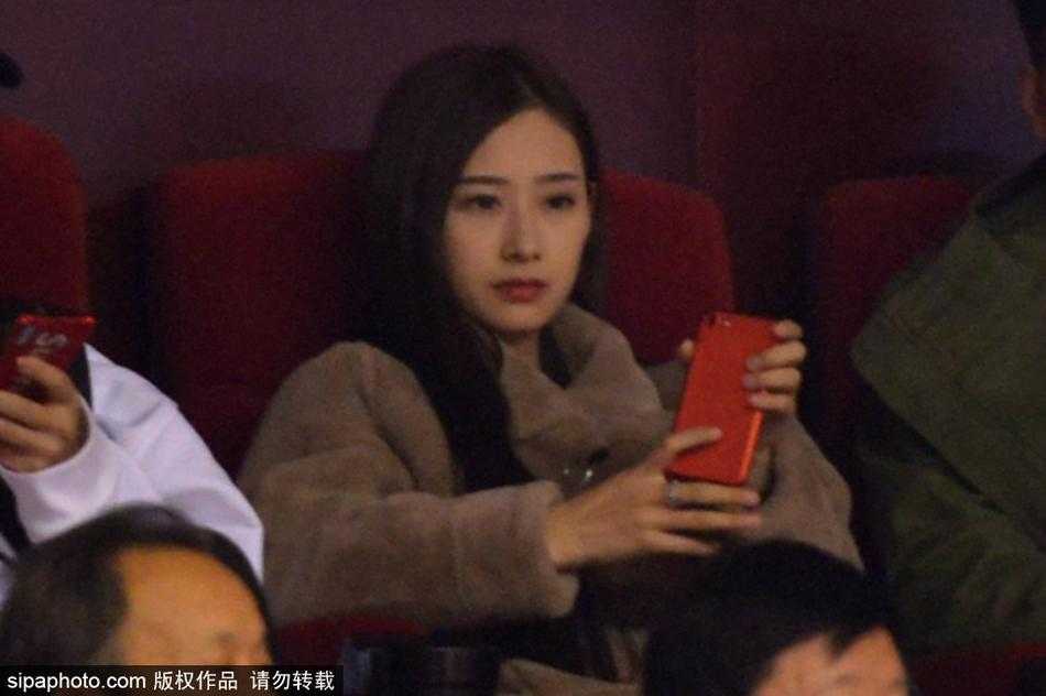 睢冉妻子戴着精致的耳饰，在球场灯光的照耀下显得格外动人，她目光坚定地望向球场方向，为场上的丈夫和队友们加油鼓劲。