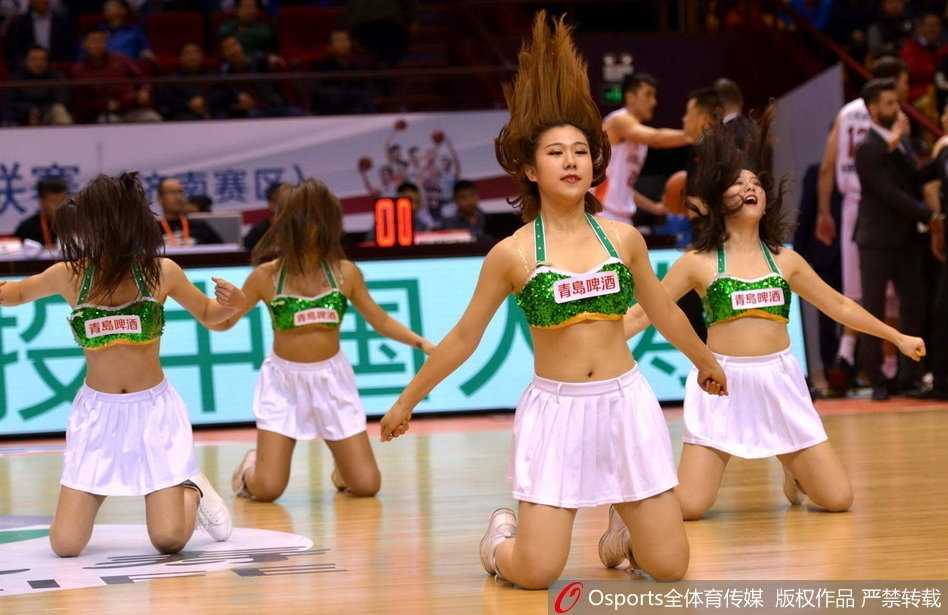 比赛暂停时段，篮球宝贝们迅速变换队形，跪地摆出极具视觉冲击力的造型，动感舞姿与背后巨大的山东男篮队徽交相辉映