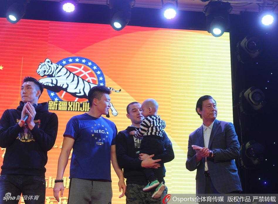 新疆全队上台合影，大家簇拥在一起，共同捧起总冠军奖杯，庆祝这历史性的时刻